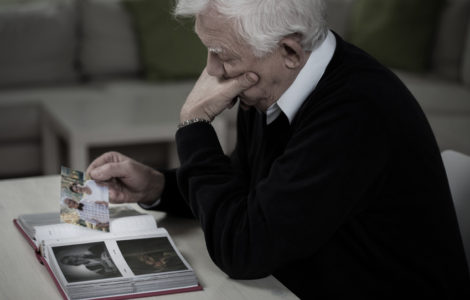 Widower looking at the photos and remembering deceased wife