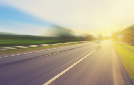 Empty asphalt road in motion blur and sunlight with vintage tone.