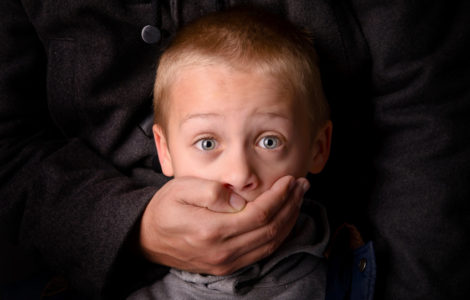 child being abducted over dark background