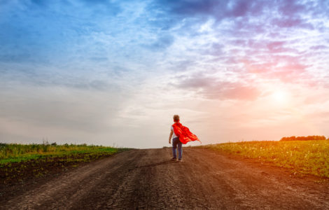 the little preschool boy, plays the superhero outdoors